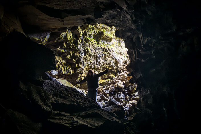 person standing inside the Arnarker lava cave
