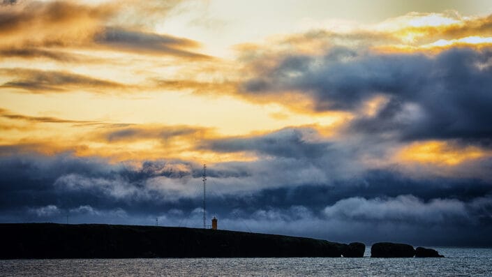 Sunset over a lighthouse on the Arctic Coast Way