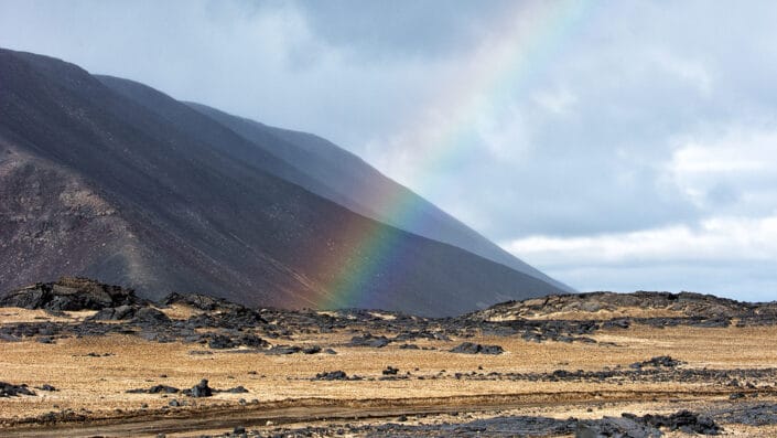 Icelandic mountains with a rainbow over the gravel F910 road