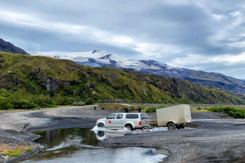 a car with a trailer crossing river Krossa in Thorsmorok