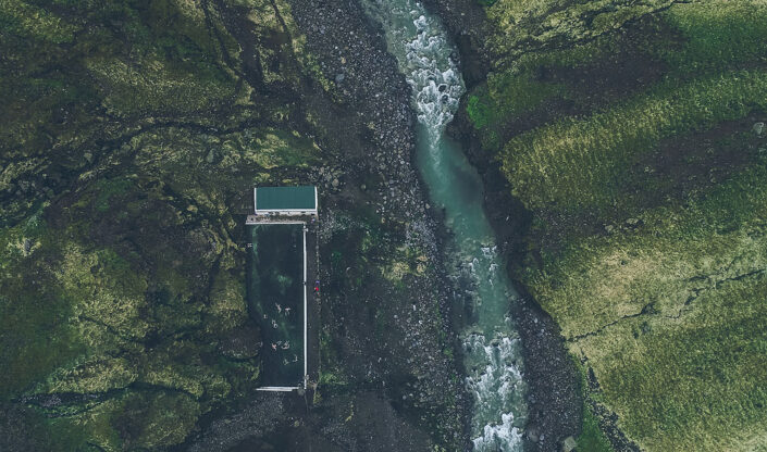 Seljavallalaug pool next to a mountain river, seen from above