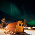 Fossatun camping pod with aurora borealis above it