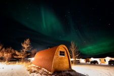 Fossatun camping pod with aurora borealis above it