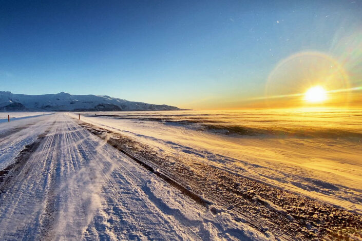 sunset over a wintery road in Iceland