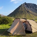 Tent pitched at Bolungarvík campsite in the Westfjords on a sunny June day, with mountain view in the background.