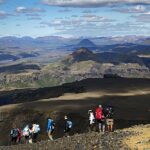 Group of hikers on the Fimmvörðuháls trail with a sweeping panorama of the Iceland highlands in the background